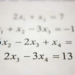 Układ równań liniowych z wyrażeniami algebraicznymi: 2x₁ + x₂ = 7, x₁ + x₂ - 3x₃ = -10, 6x₂ - 2x₃ + x₄ = 7, 2x₃ - 3x₄ = 13.