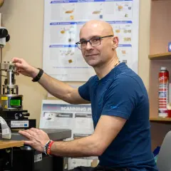 Naukowcowiec pracuje przy zaawansowanym sprzęcie, który umożliwia badania w skali nanotechnologii.
