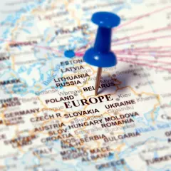 Mapa Europy z zaznaczonymi krajami, w tym Polską i Ukrainą. Niebieska pinezka wbita w Europę.