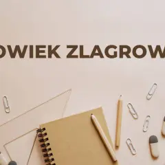 Człowiek zlagrowany, ofiara systemu, otoczony przyborami szkolnymi.