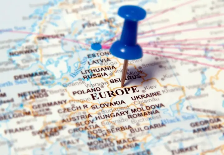 Mapa Europy z zaznaczonymi krajami, w tym Polską i Ukrainą. Niebieska pinezka wbita w Europę.