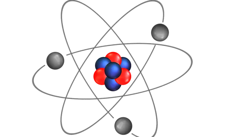 Schemat budowy atomu: jądro z czerwonych i niebieskich cząstek otoczone orbitującymi szarymi elektronami.