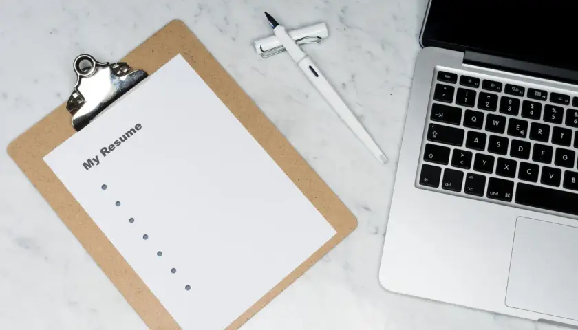 Przygotowuję CV po angielsku (My Resume) na laptopie, obok leży długopis.