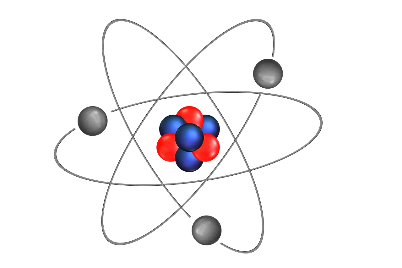 Schemat budowy atomu: jądro z czerwonych i niebieskich cząstek otoczone orbitującymi szarymi elektronami.