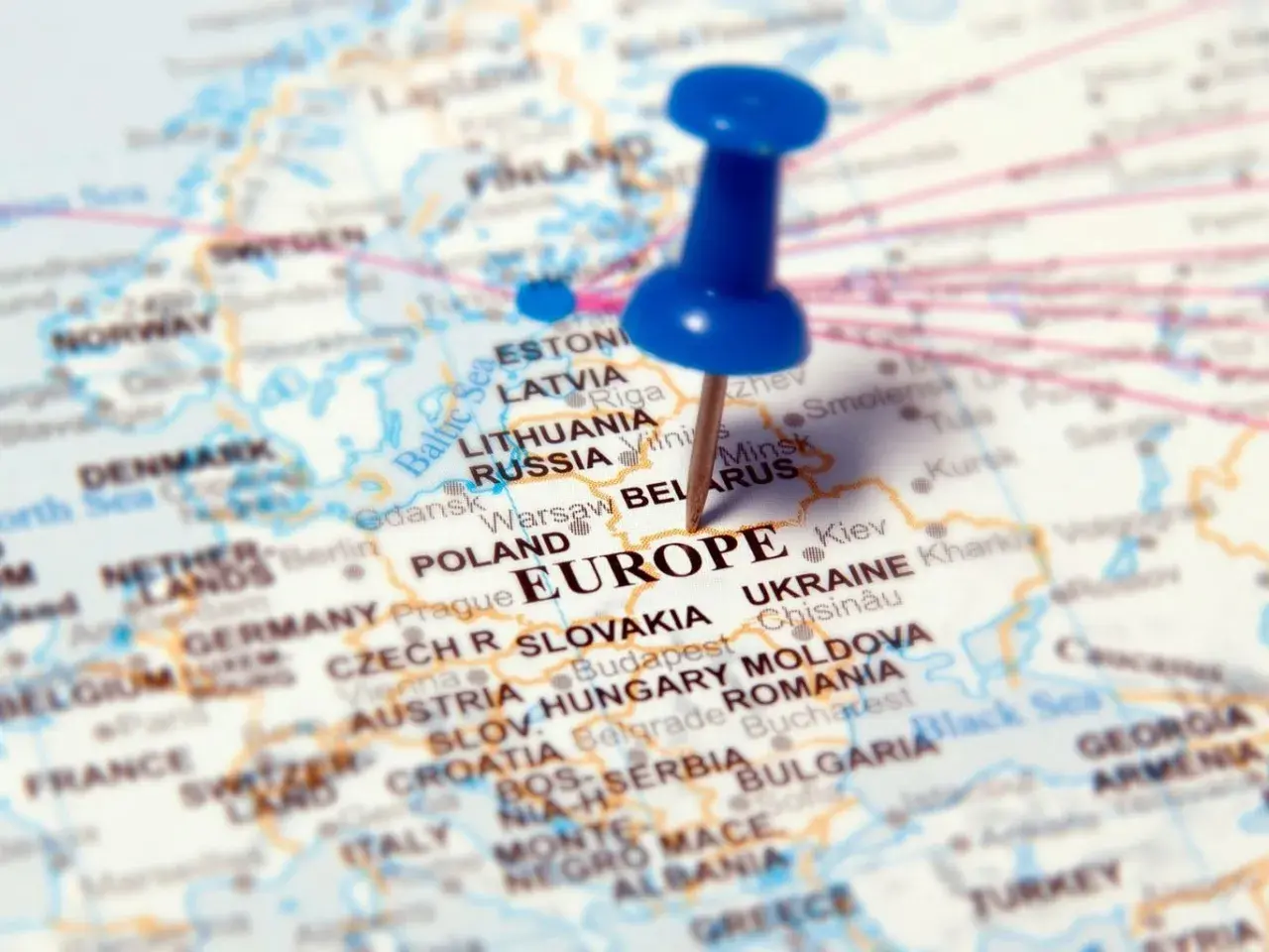 Mapa Europy z zaznaczonymi krajami, w tym Polską i Ukrainą. Niebieska pinezka wbita w Europę.