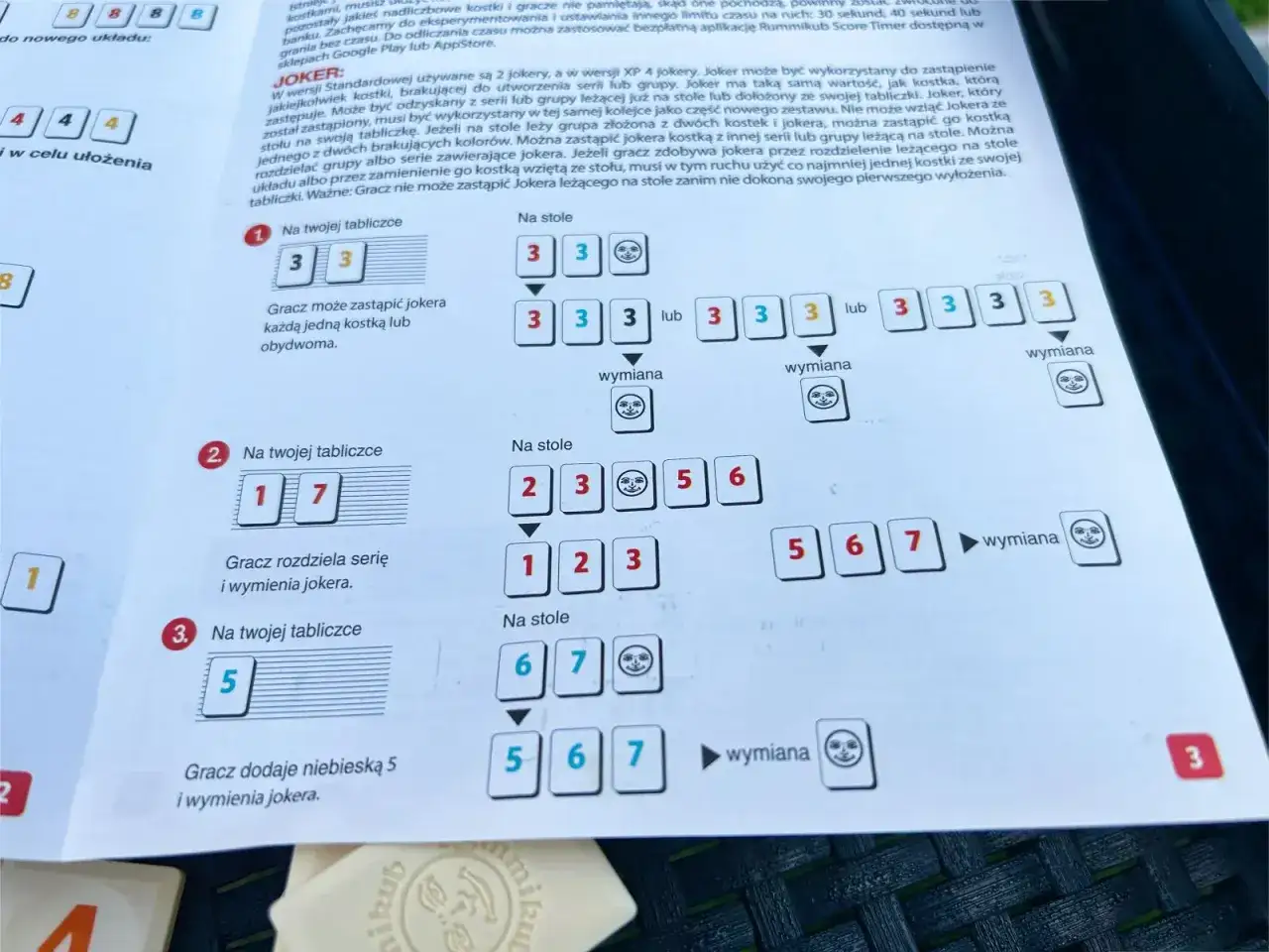 Zasady gry Rummikub: przykłady tworzenia serii i wymiany jokera na stole i na tabliczce gracza.